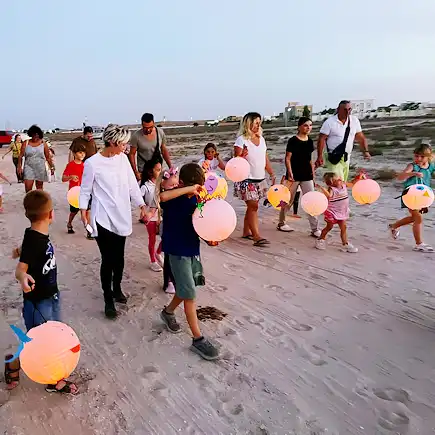 Families and children walking with lanterns during a community event at Al Jazeerah Equestrian Club.